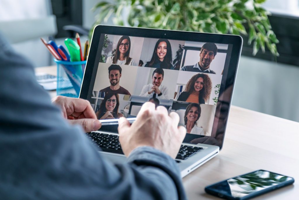 man video calling his team while working remotely