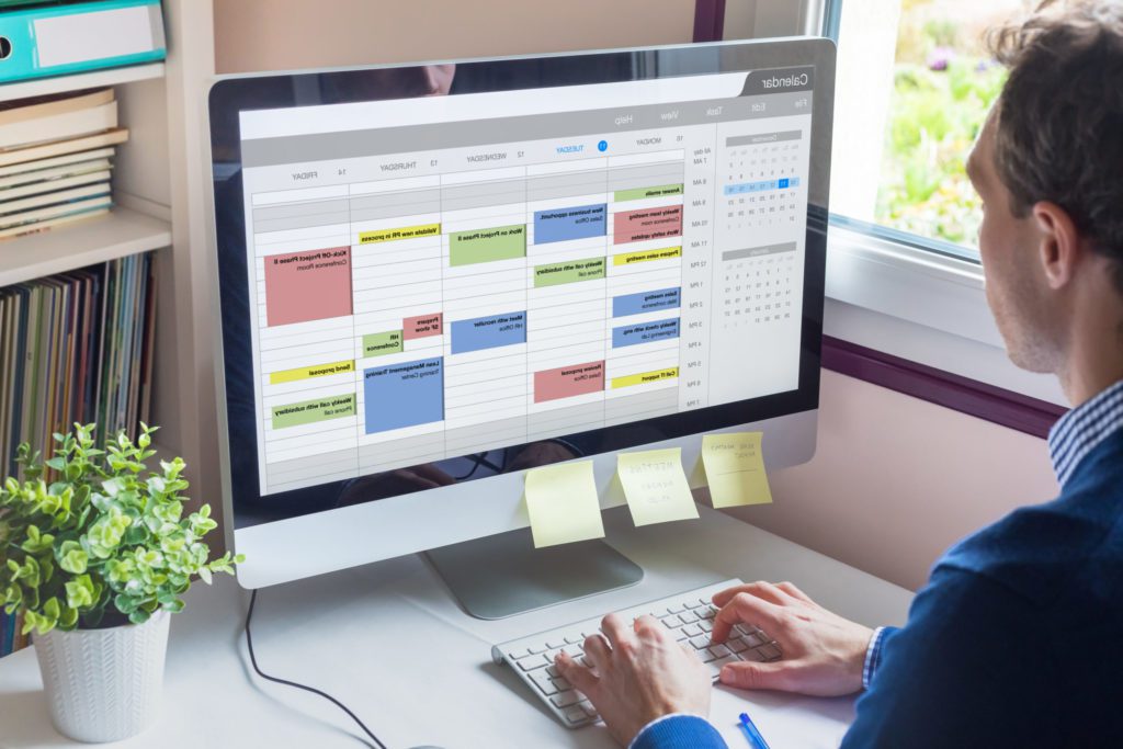 man working on a spreadsheet on a mac computer